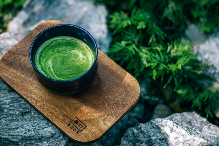 taza con té verde en tabla de madera vista desde arriba
