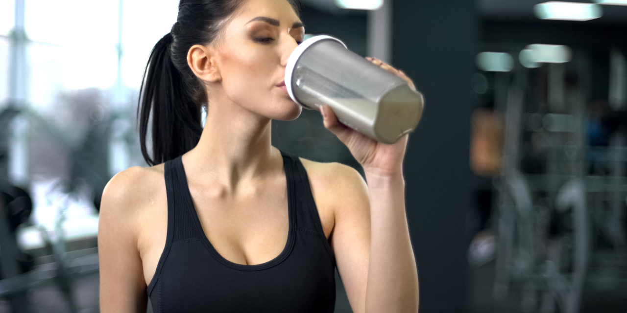 Chica deportista tomando un batido de proteínas