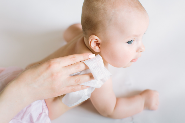 Mano con toallita limpiando a un bebé