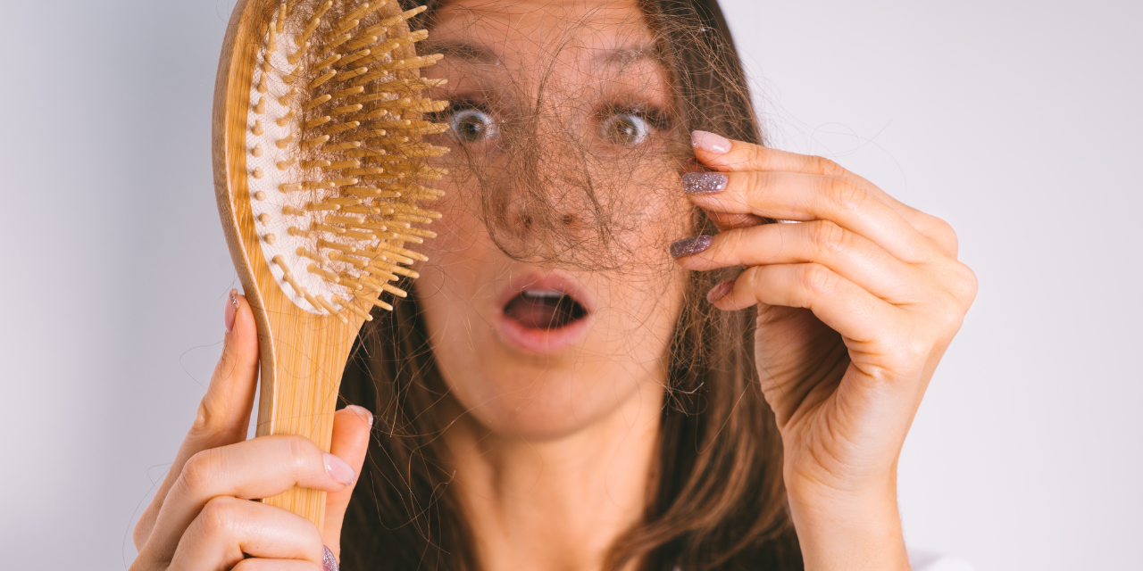 Mujer sujetando un cepillo lleno de pelo